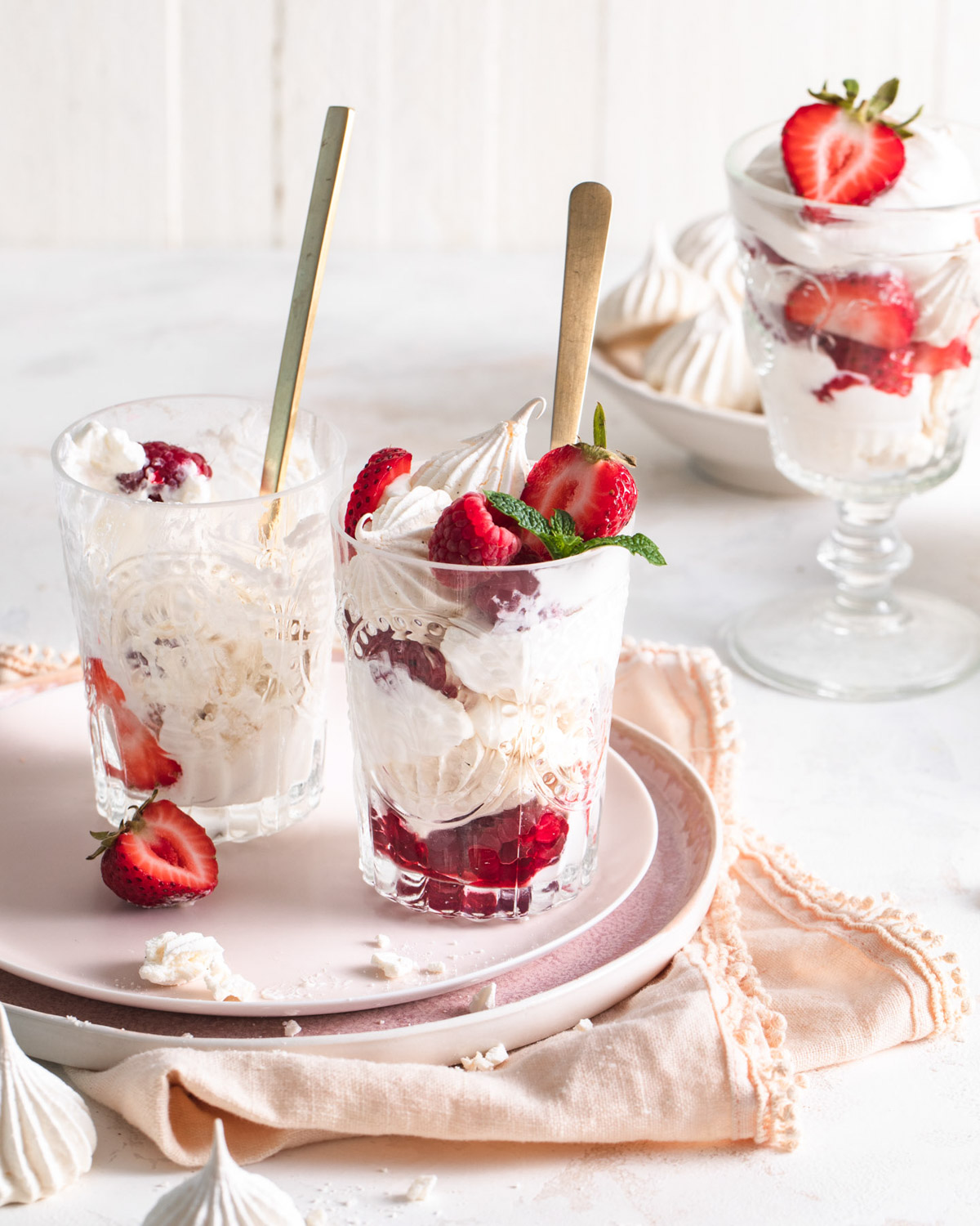 Eton mess in glasses that have been half eaten with a spoon