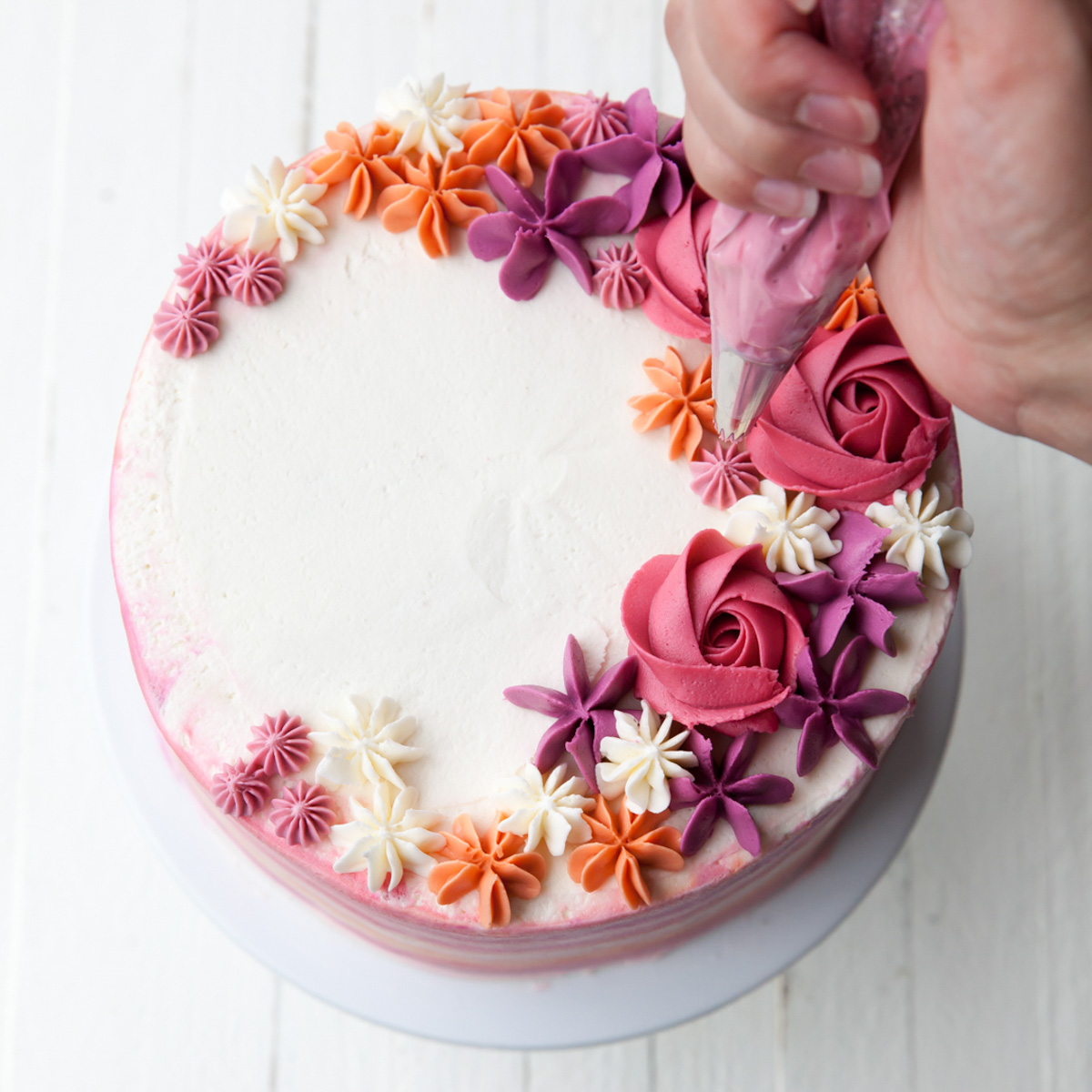 How to make a buttercream flower cake by piping buttercream with a star tip
