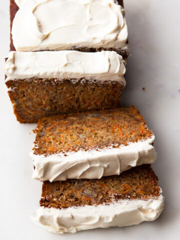 slices of honey carrot banana bread with cream cheese frosting