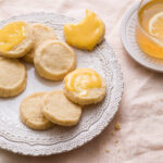 A plate of shortbread cookies with swirls of lemon curd on top
