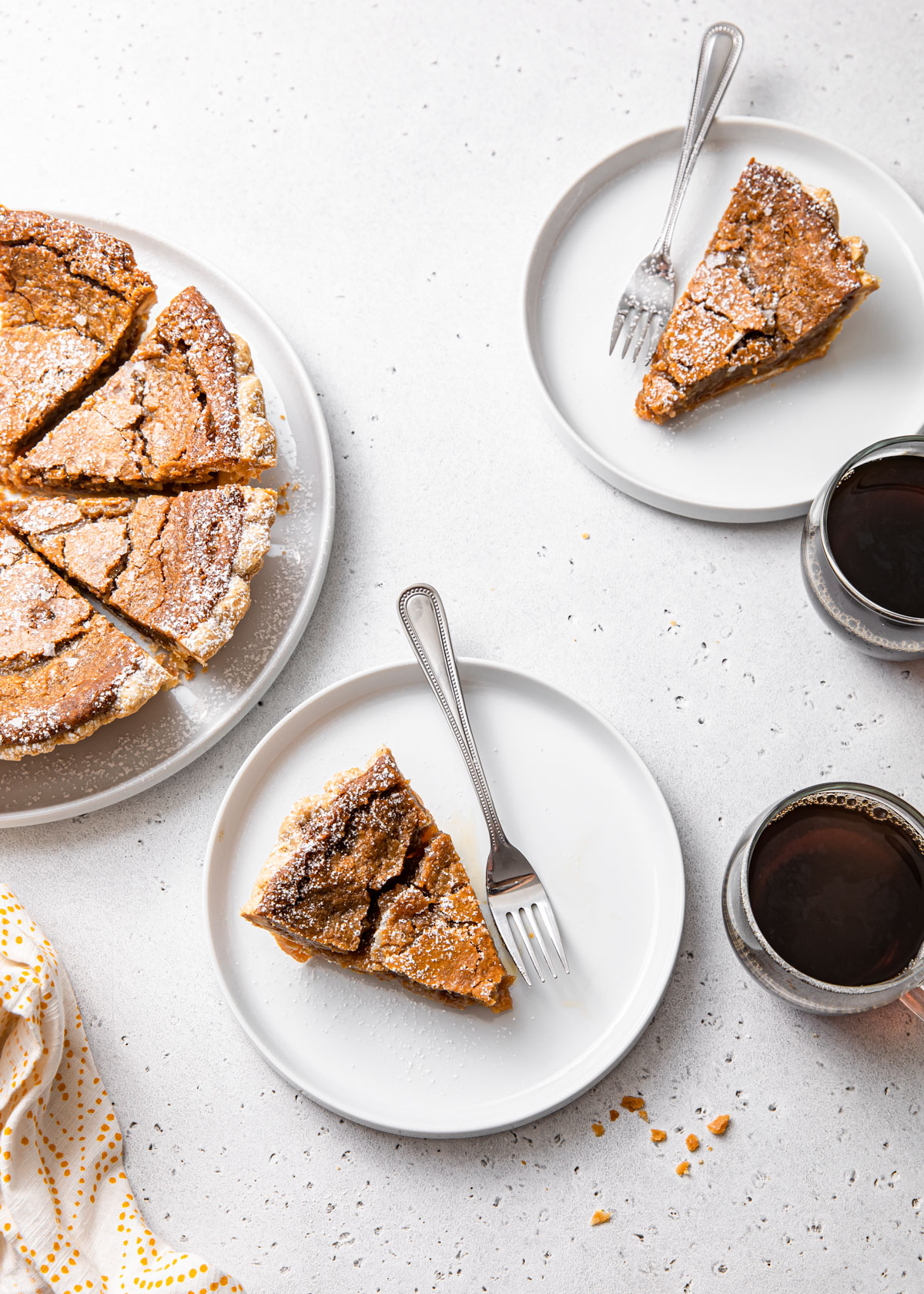 An overhead image of slices of maple sugar pie and cups of coffee