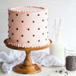 A pink cake with chocolate chip polka dots and cookie filling
