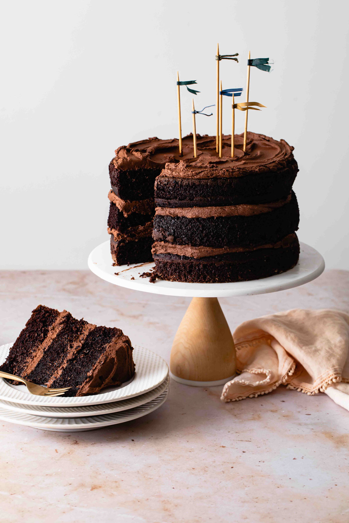 Three layers of moist chocolate cake with fudge frosting with a slice removed