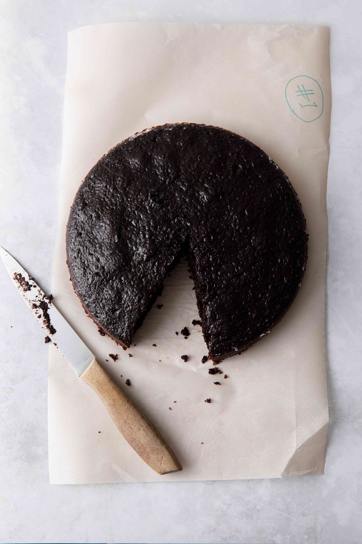 One layer of chocolate cake on a piece of parchment paper