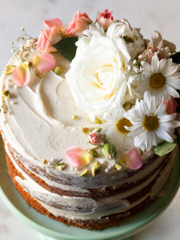 White and pink flowers on a naked cake