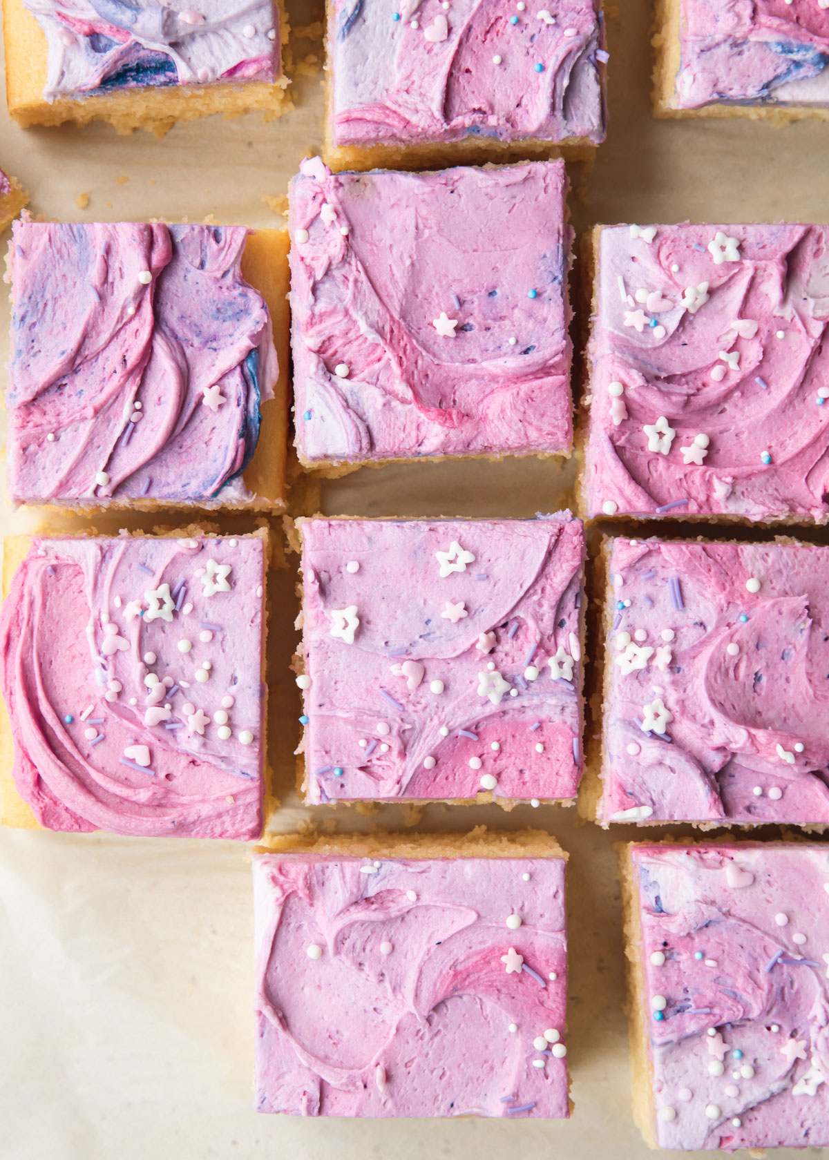 Square slices of vanilla sheet cake with swirly purple buttercream