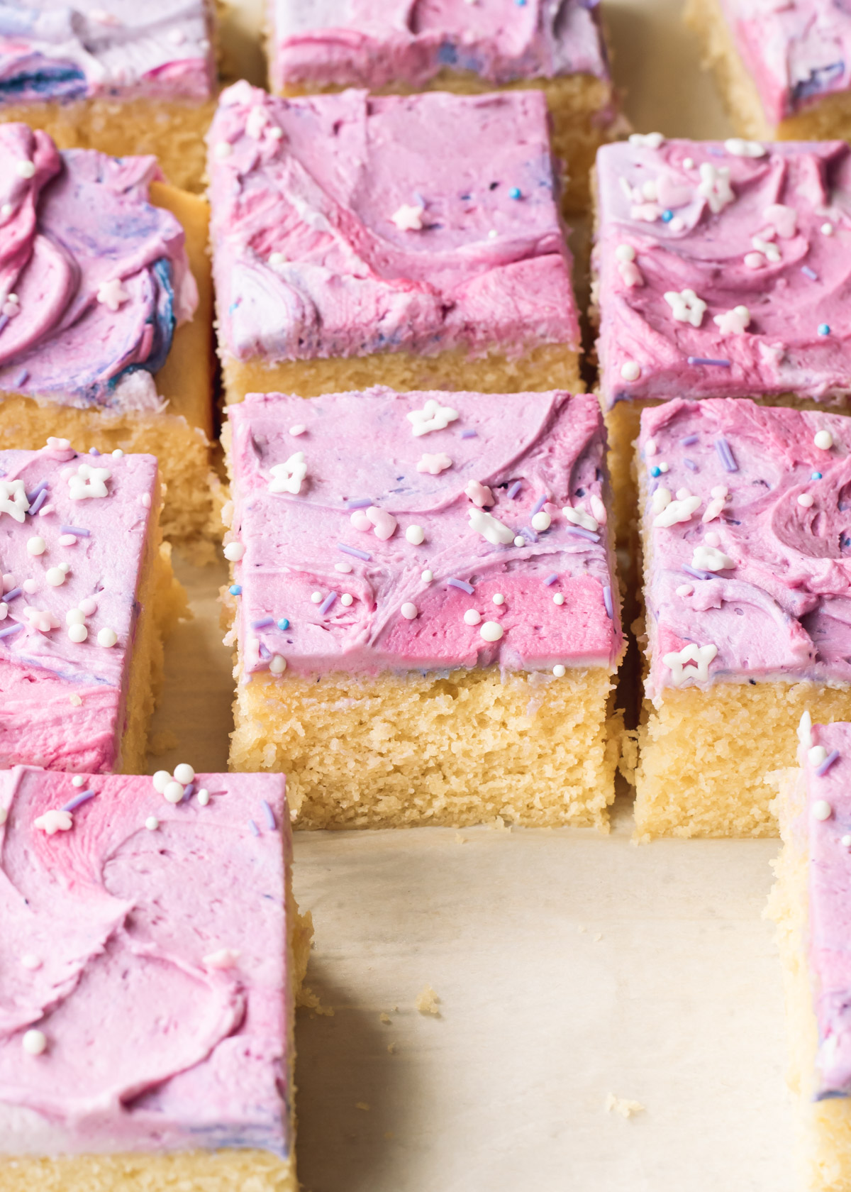 Square slices of vanilla sheet cake with swirly purple buttercream