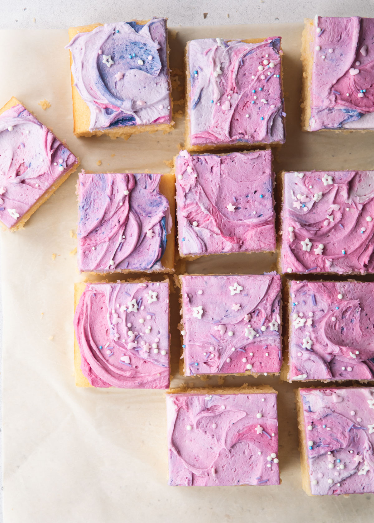 Square slices of vanilla sheet cake with swirly purple buttercream