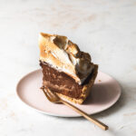 A slice of peanut butter s'mores pie with toasted marshmallow on top