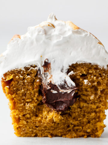 The inside of a pumpkin s'mores cupcake with toasted meringue on top