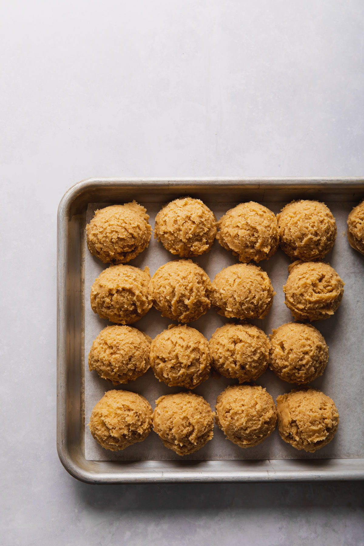 pumpkin snickerdoole dough scooped out onto a baking sheet