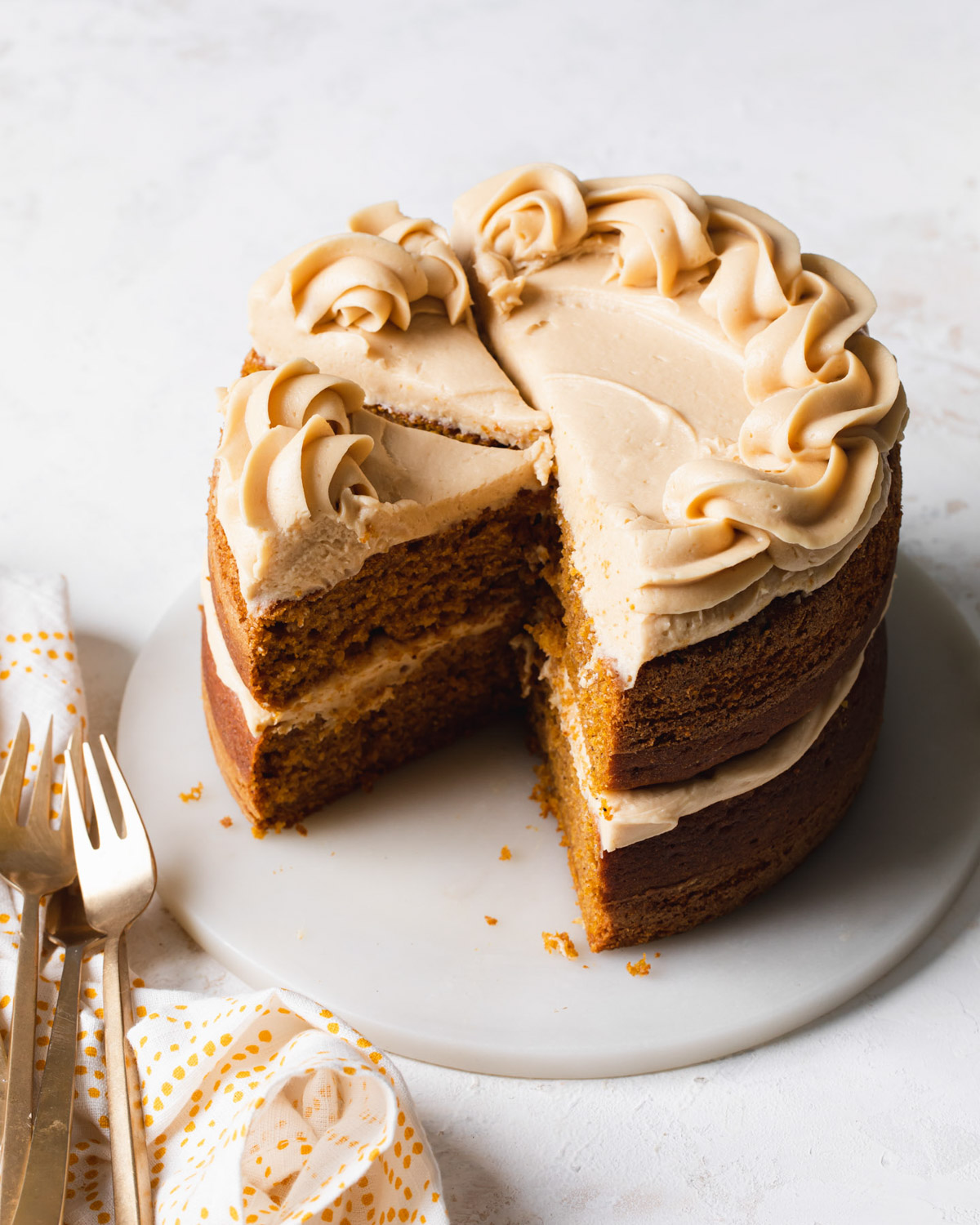 A two-layer pumpkin cake with coffee cream cheese frosting that has been sliced