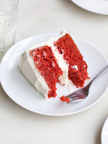 A slice of red velvet cake with cream cheese frosting