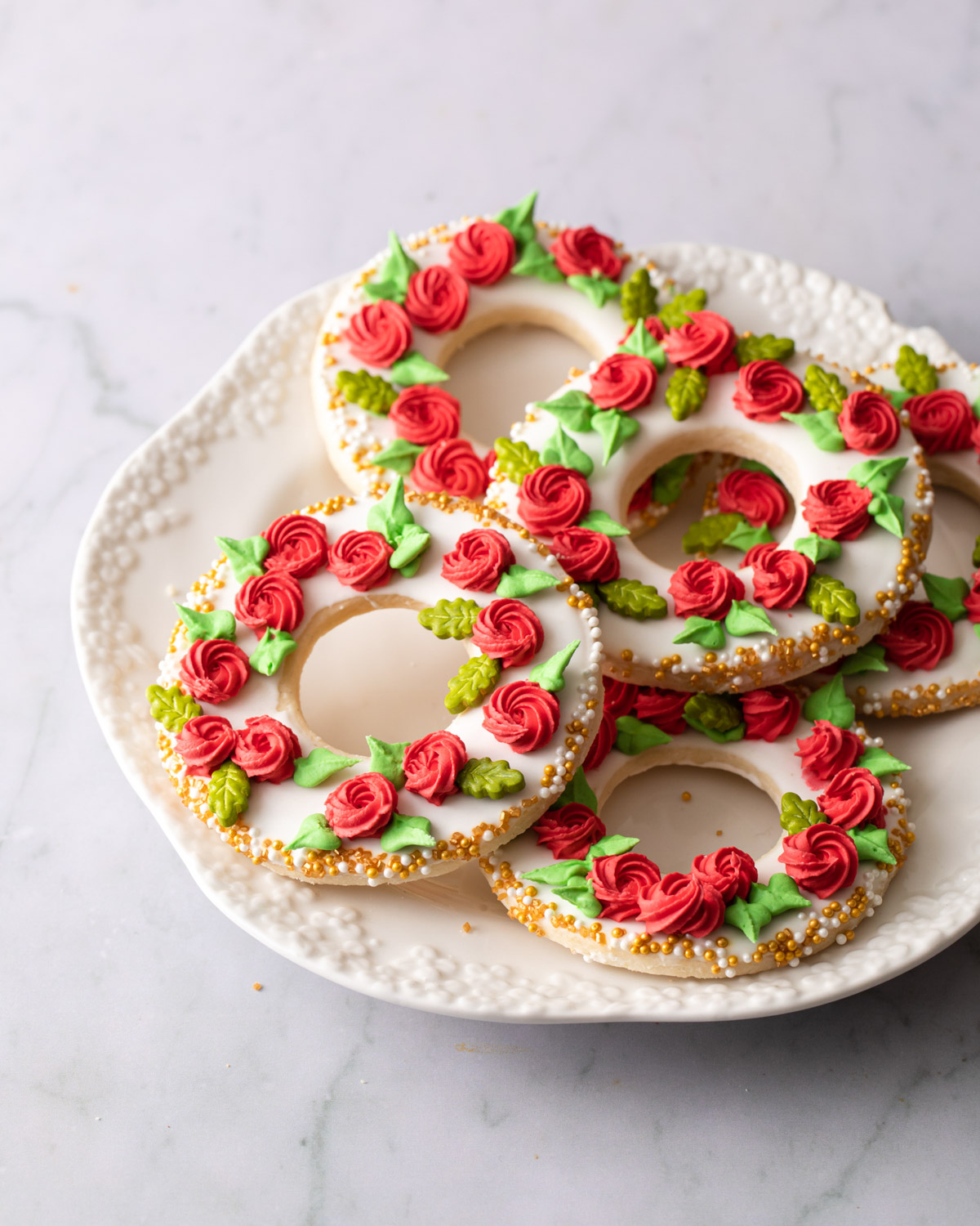 A plate of Christmas wreath cookies decorated with icing rosettes