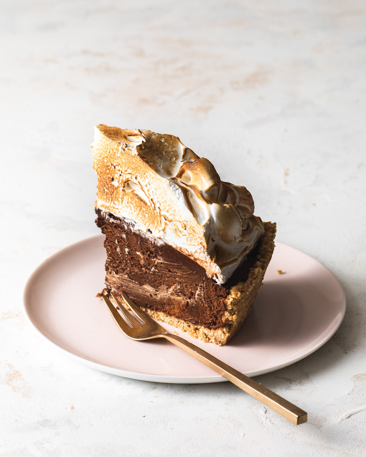 A slice of peanut butter s'mores pie with toasted meringue topping