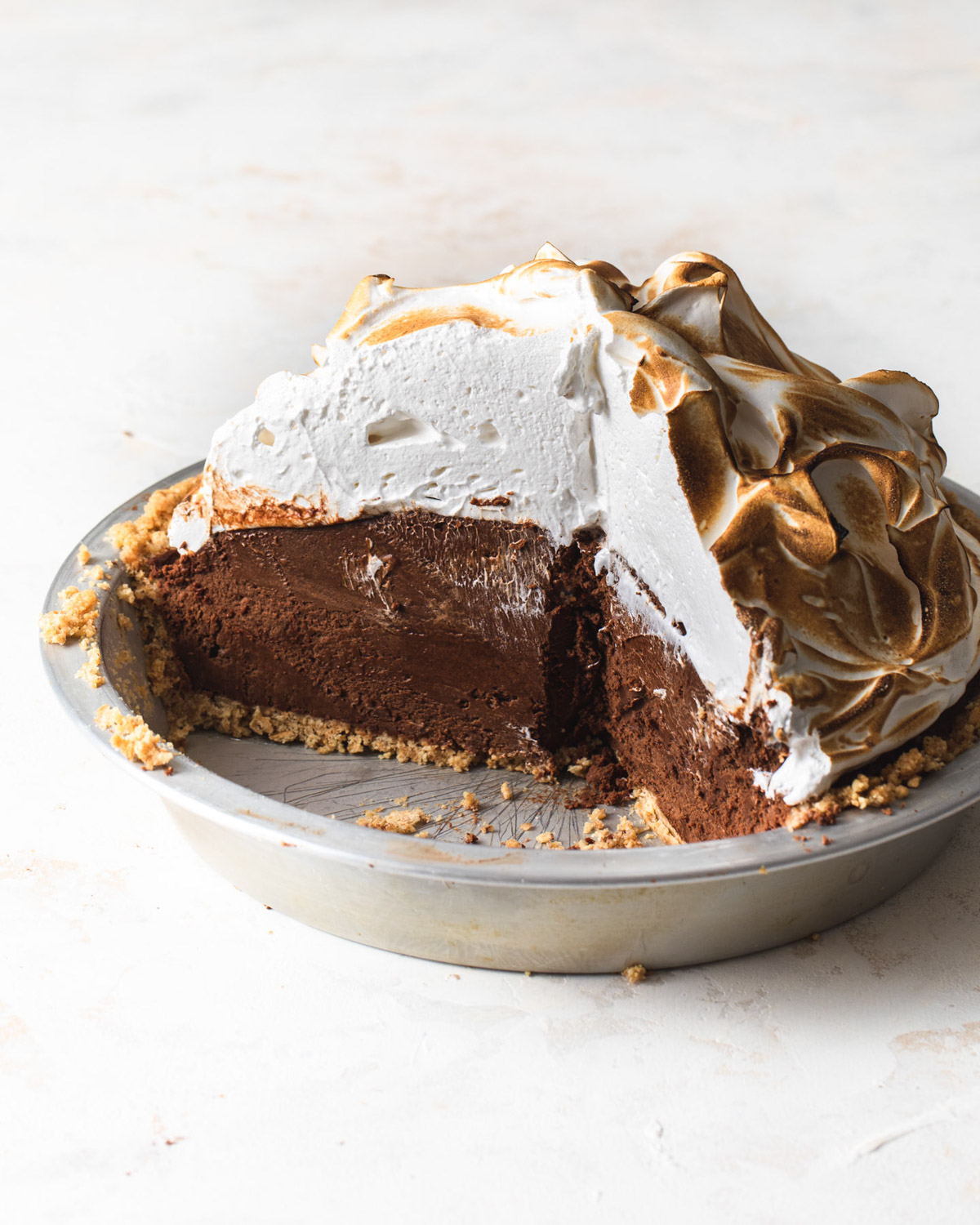 A peanut butter s'mores pie with toasted meringue topping that's been sliced open