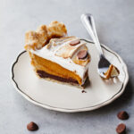 A slice of pumpkin pie with torched meringue on the top