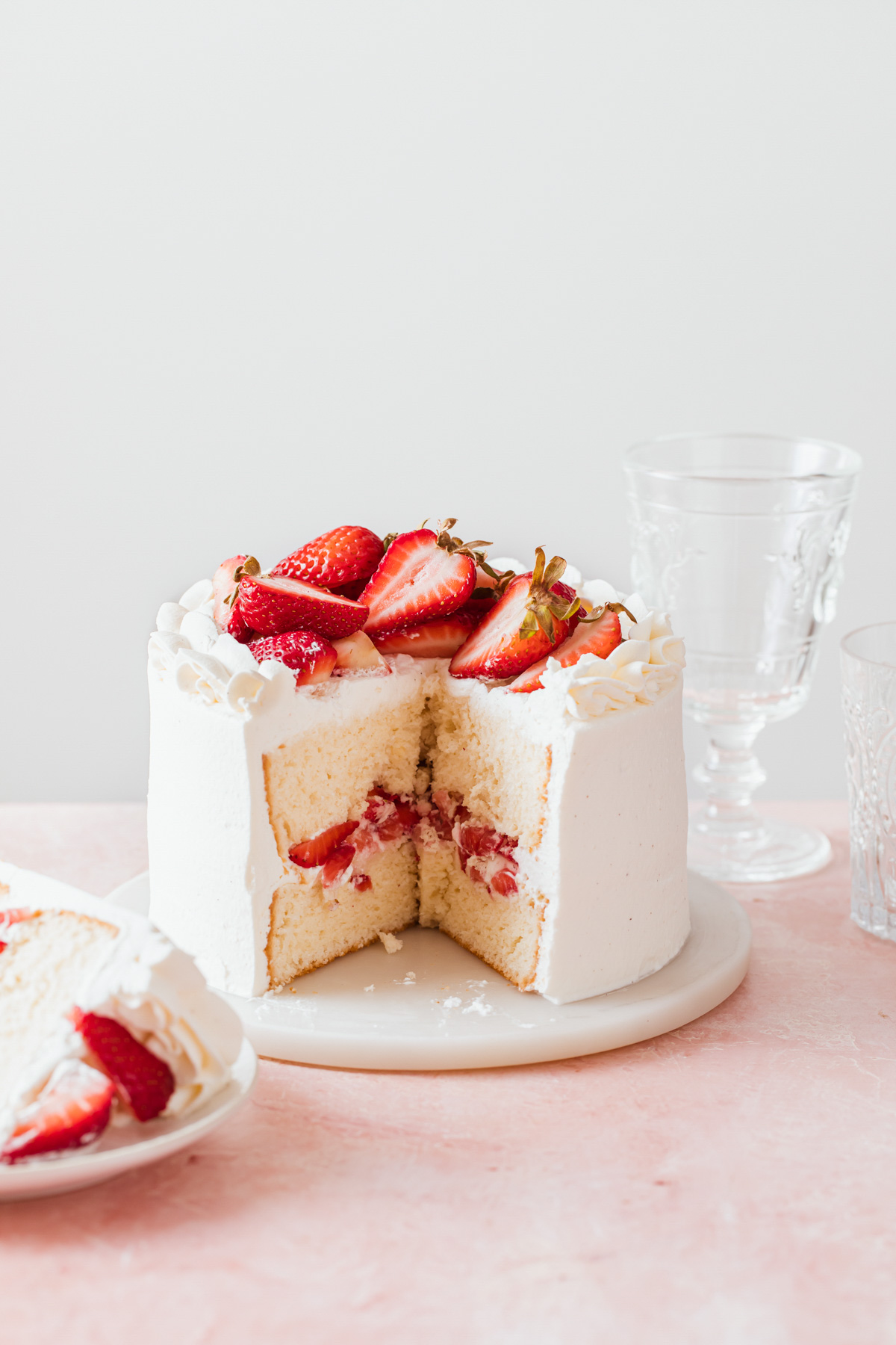 A mini strawberry chiffon cake with fresh berries and whipped cream frosting