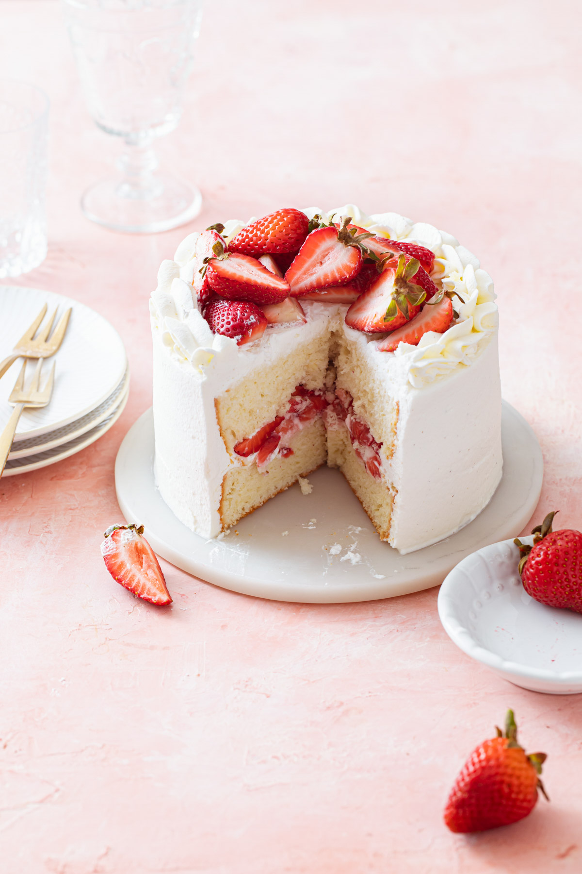 A mini two layer chiffon cake with strawberry filling and whipped cream frosting