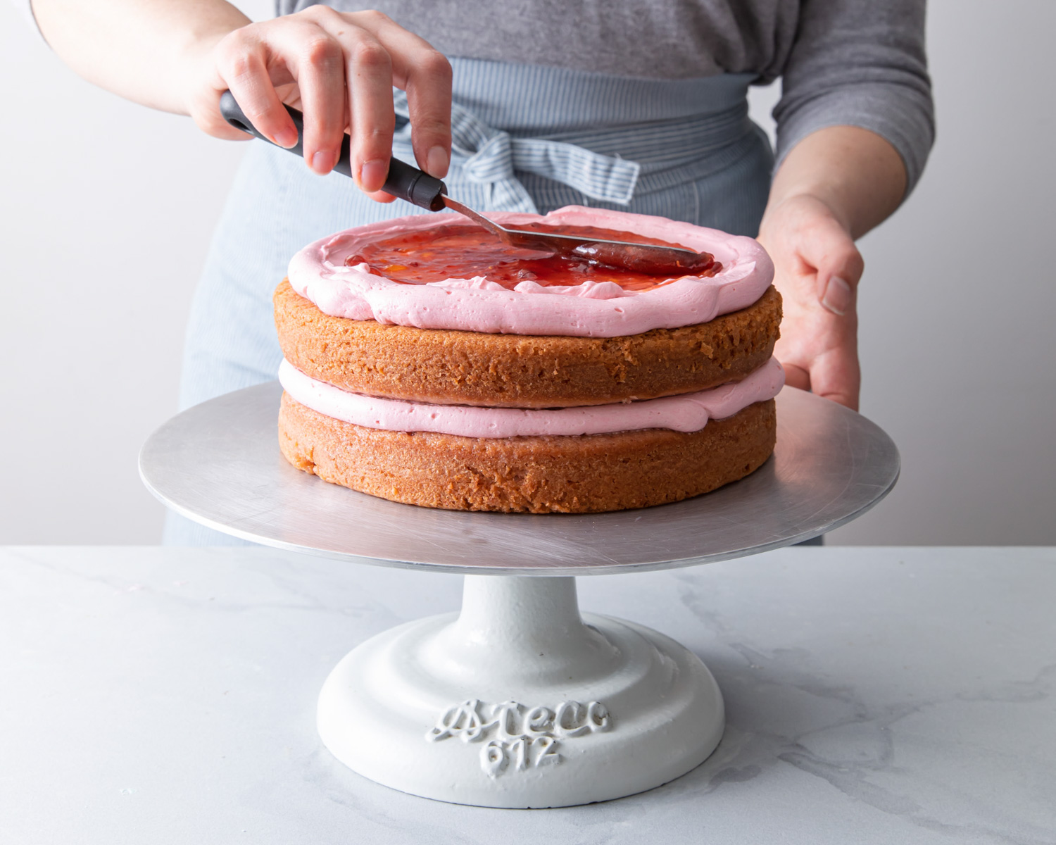 Filling a strawberry cake with strawberry jam