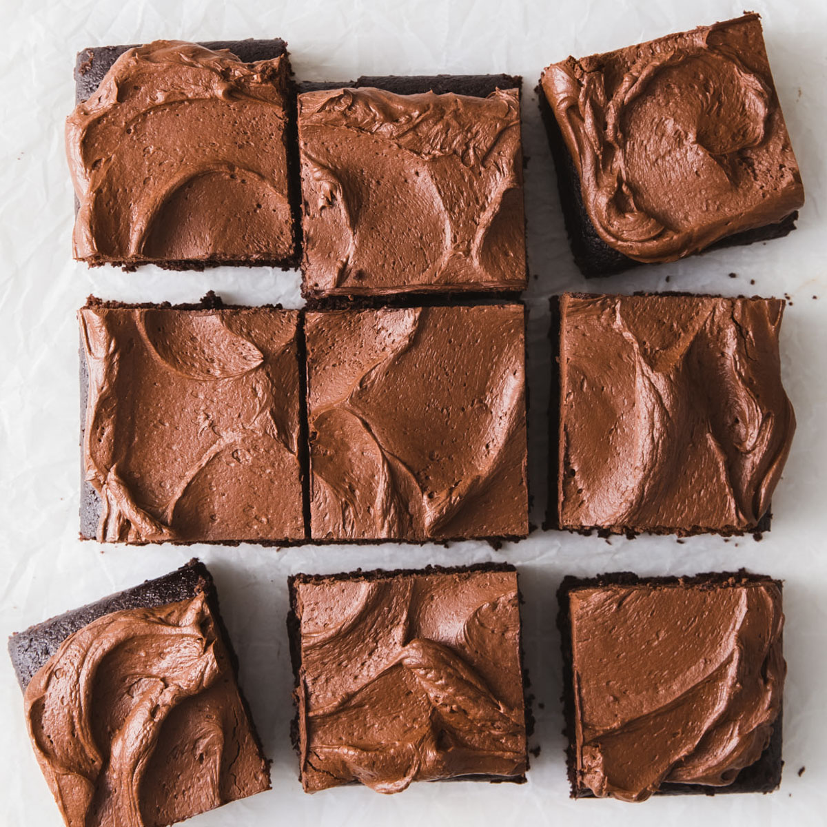 Slices of chocolate cake with whipped ganache frosting on top