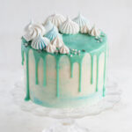 A wintery blue drip cake with meringues on top