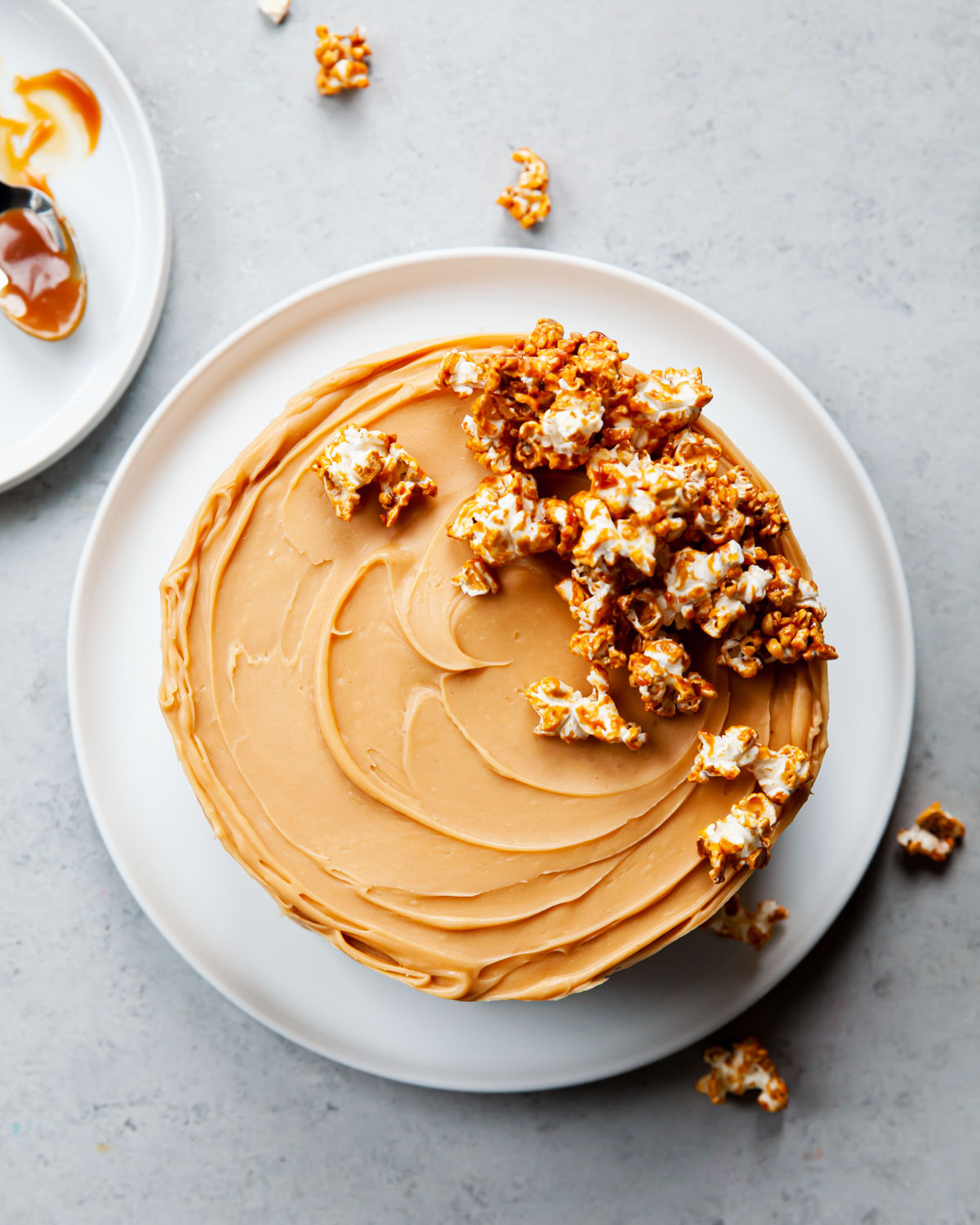 An overhead image of a caramel frosting cake with caramel popcorn on top