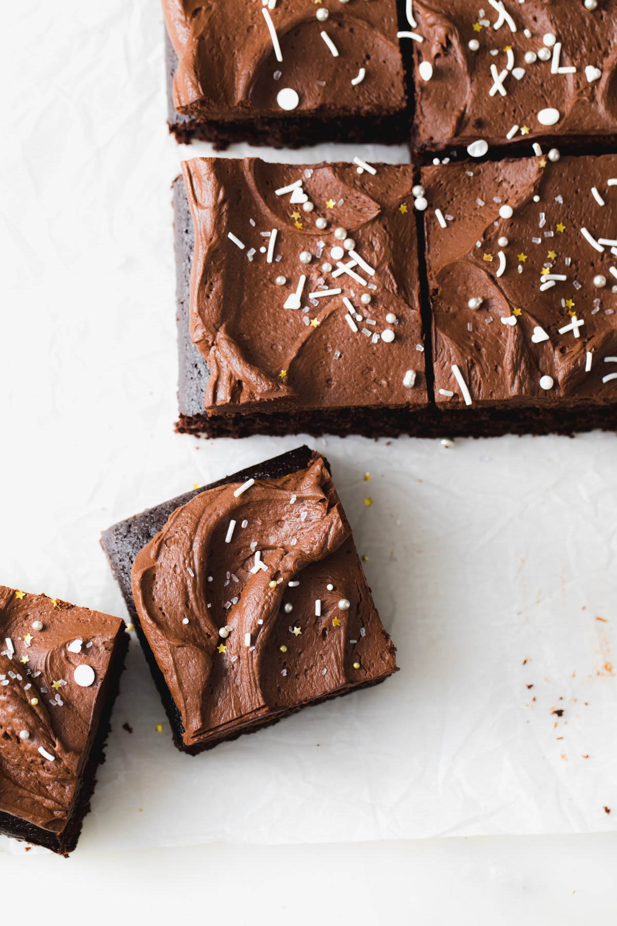 Squares of chocolate snack cake with whipped ganache on top