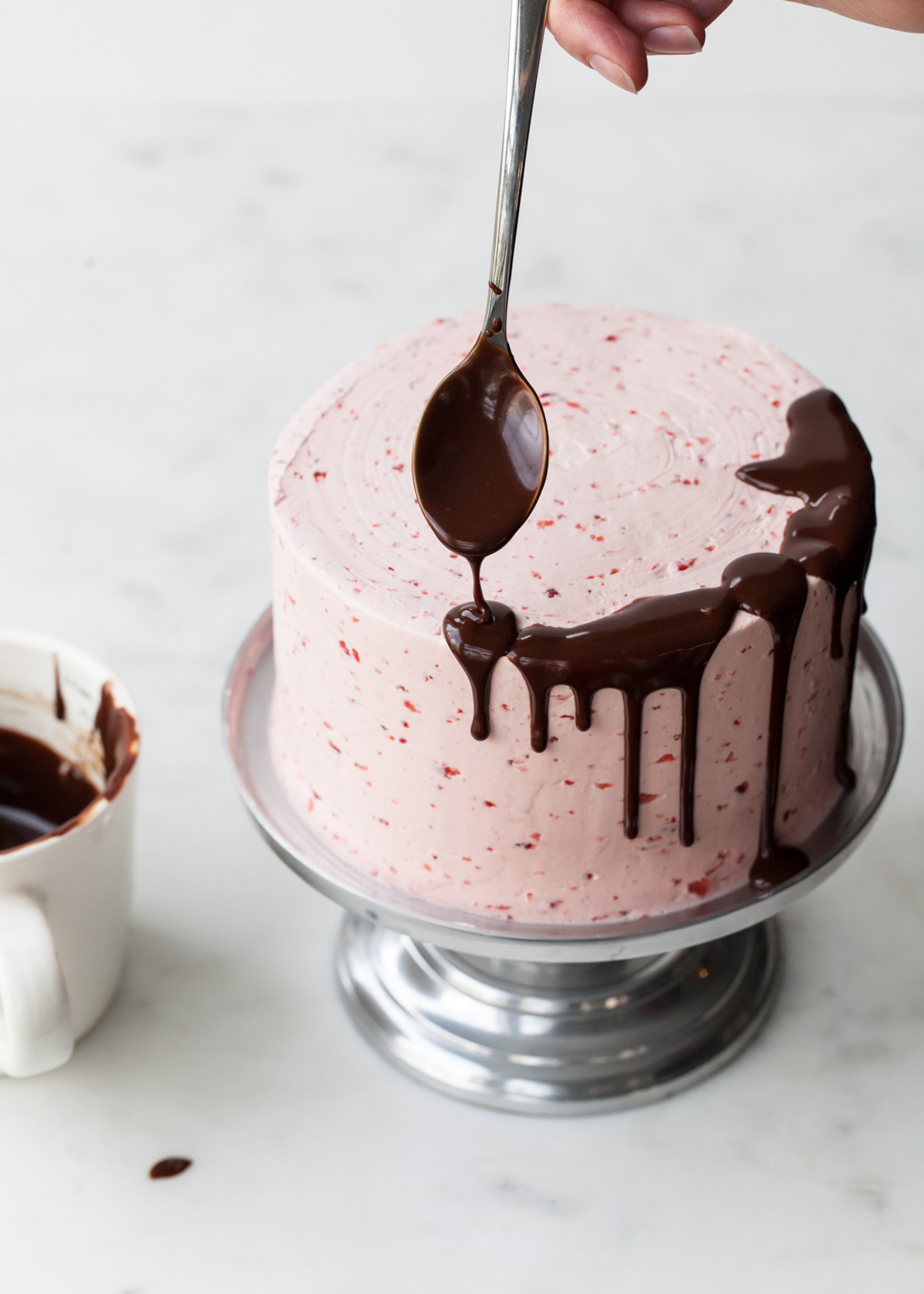 Making a chocolate drip cake with a spoon