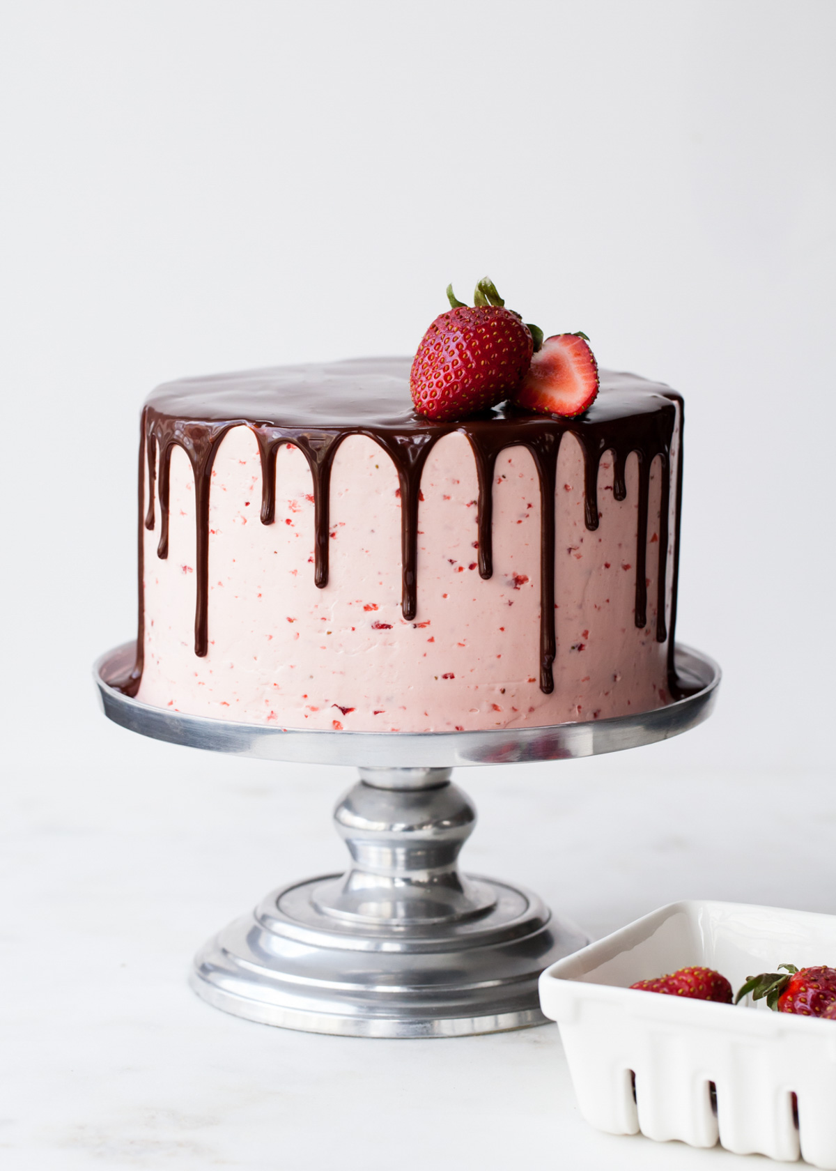 A chocolate drip cake with strawberry buttercream