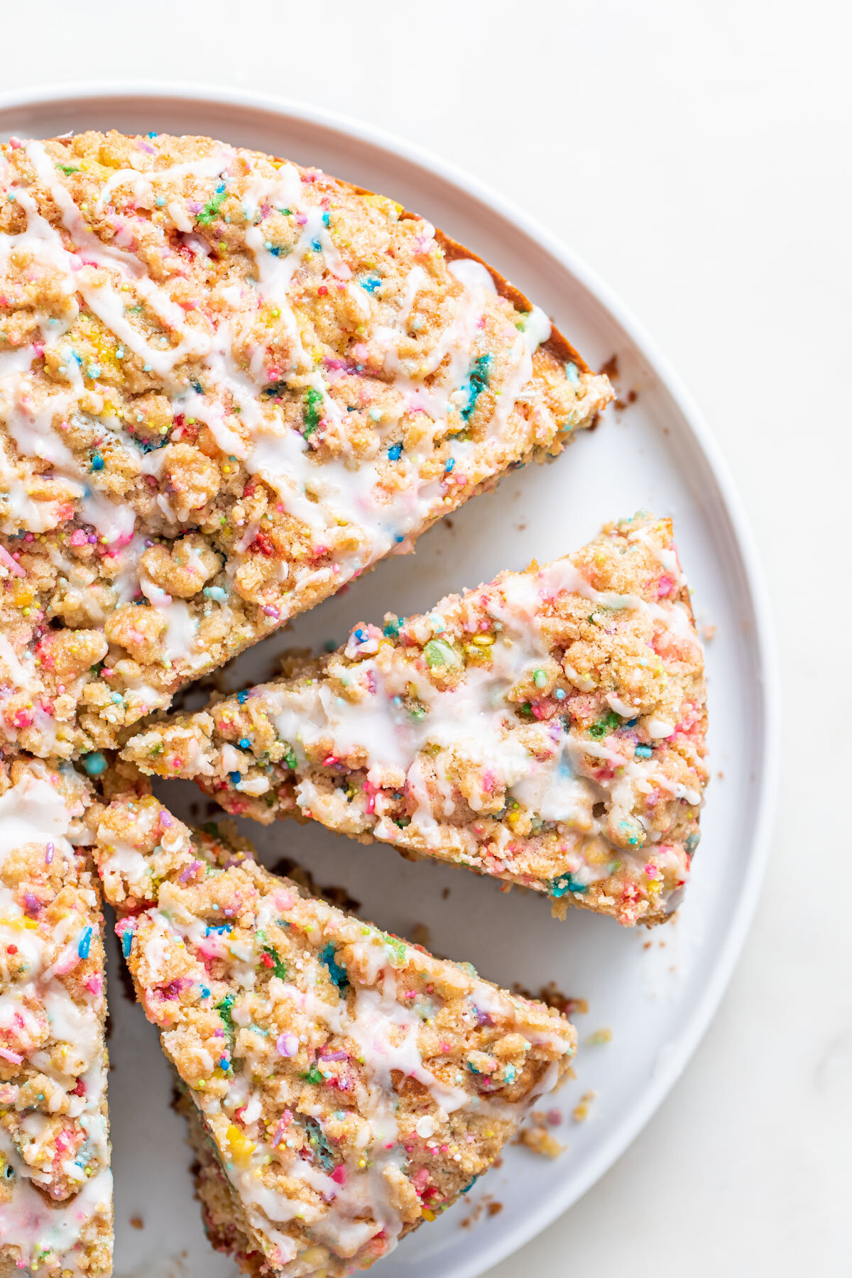 a slice of funfetti coffee cake with sprinkles and vanilla glaze