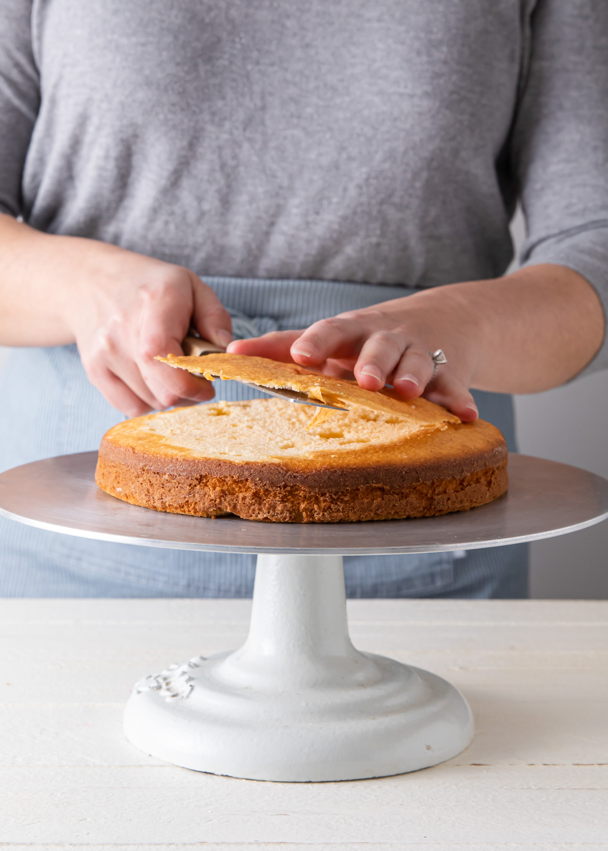 Trimming the top of a cake until flat