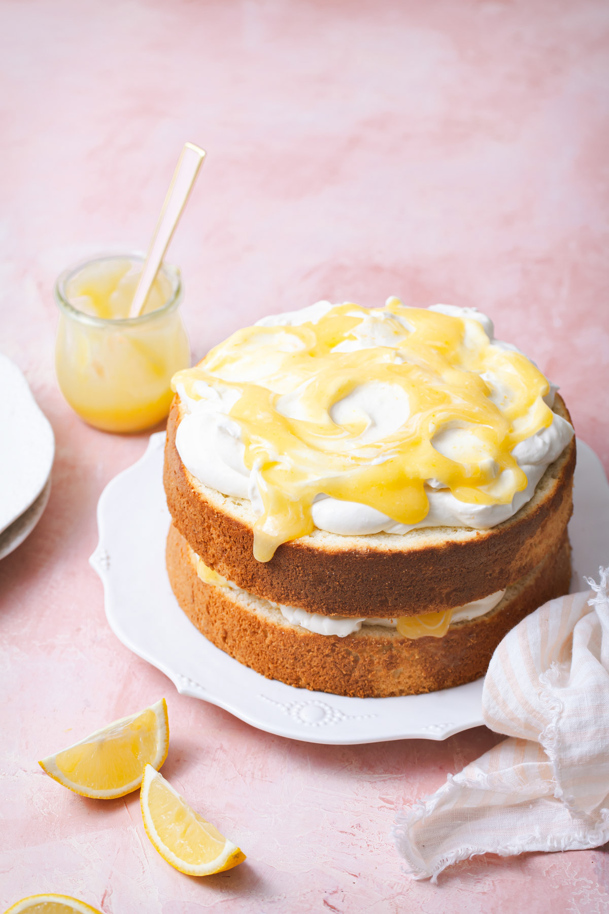 A two layer lemon chiffon cake with mascarpone cream and swirls of lemon curd on top