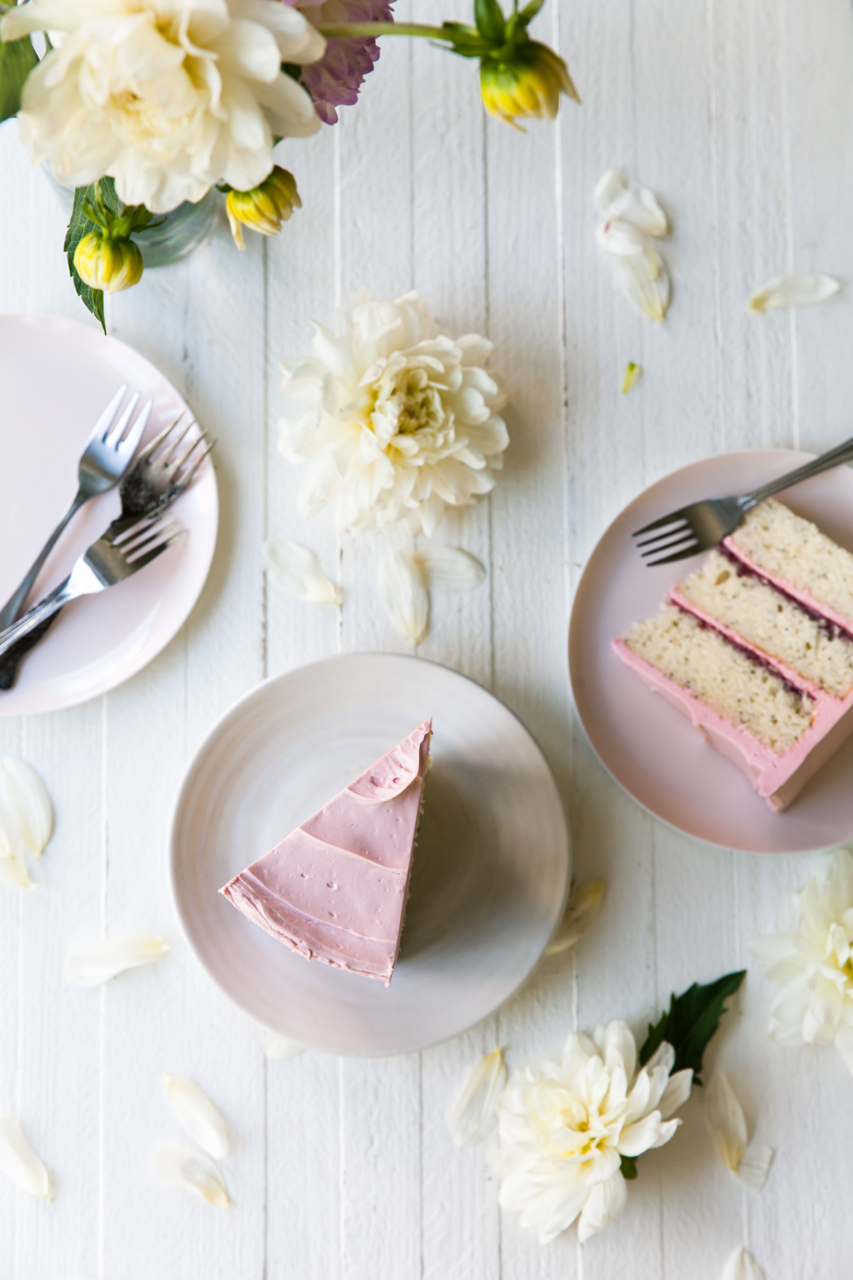 slices of lemon poppy seed cake with raspberry jam and pink French buttercream