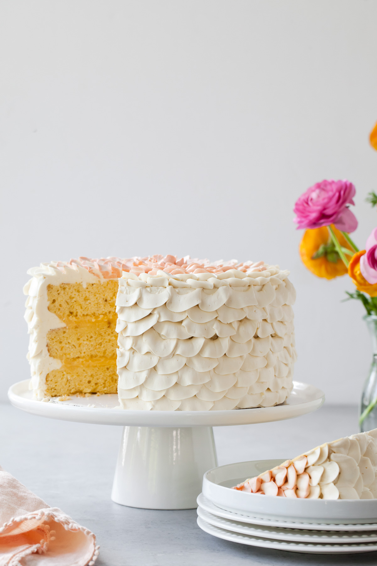 Three layers of orange cake sliced open on a cake stand