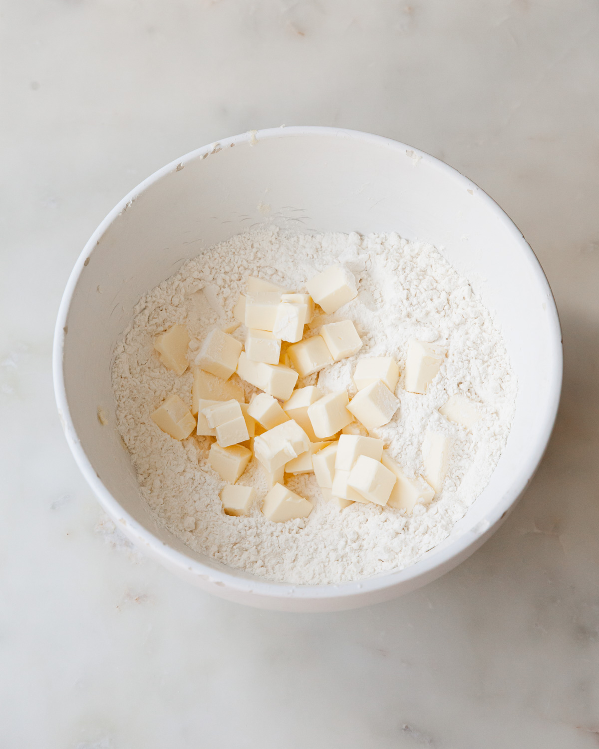 Cubed butter in a bowl of flour to make pie dough