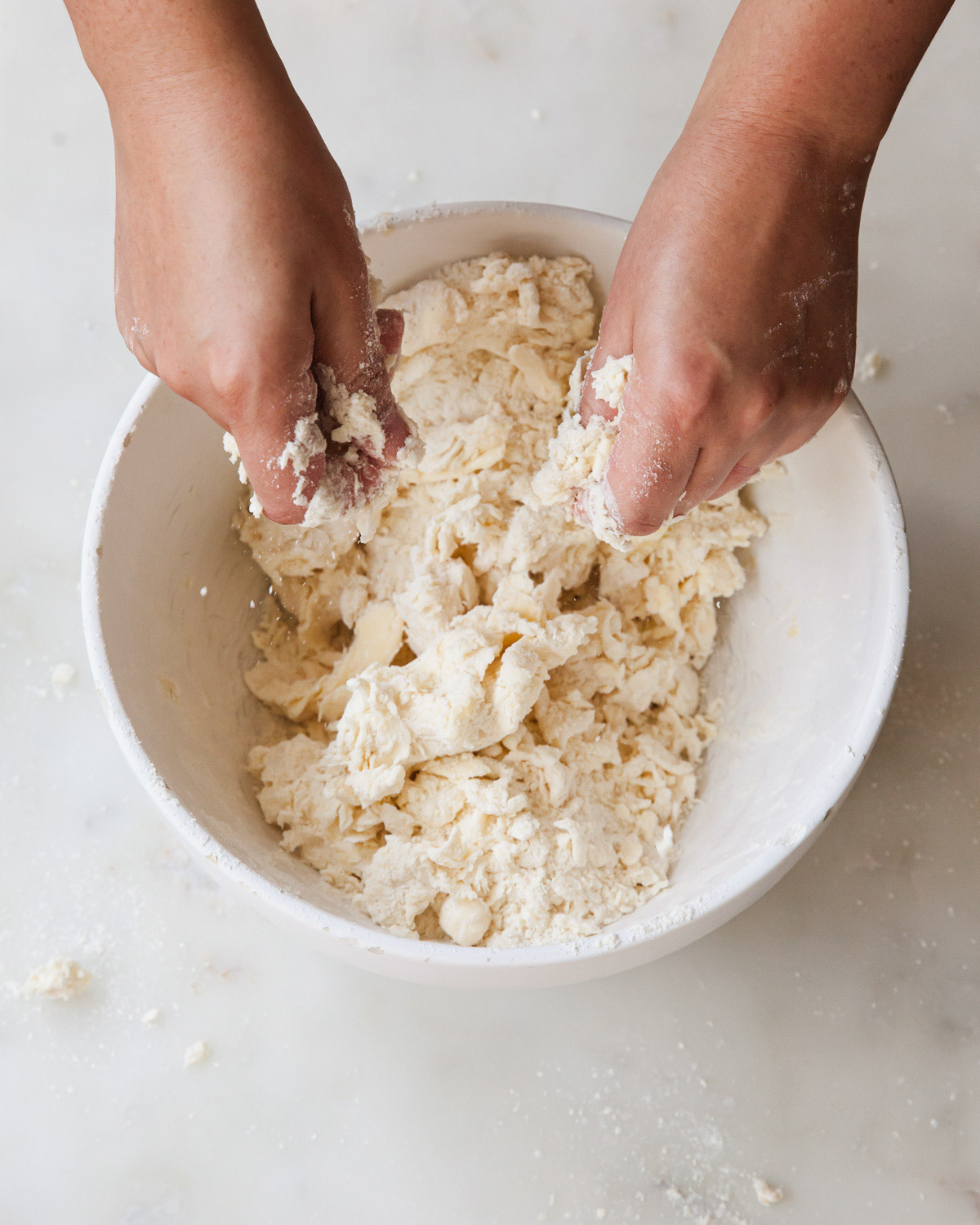 Mixing pie dough by hand in a mixing bowl