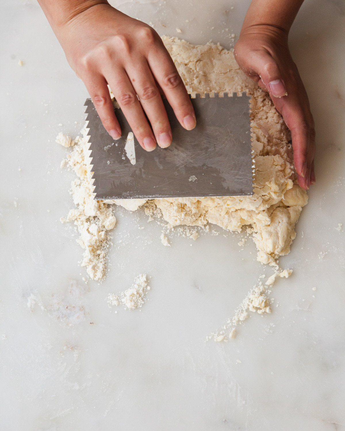 folding pie dough by hand and a bench scraper