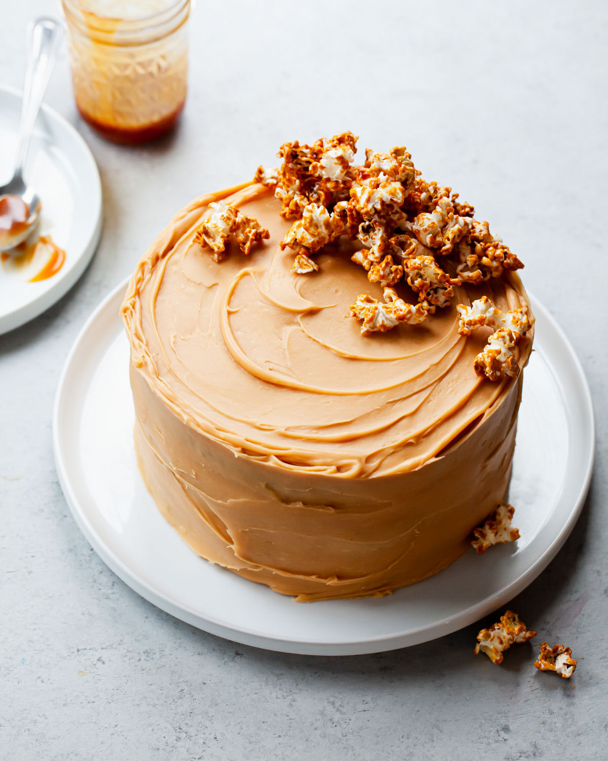 A caramel frosted cake with caramel popcorn on top