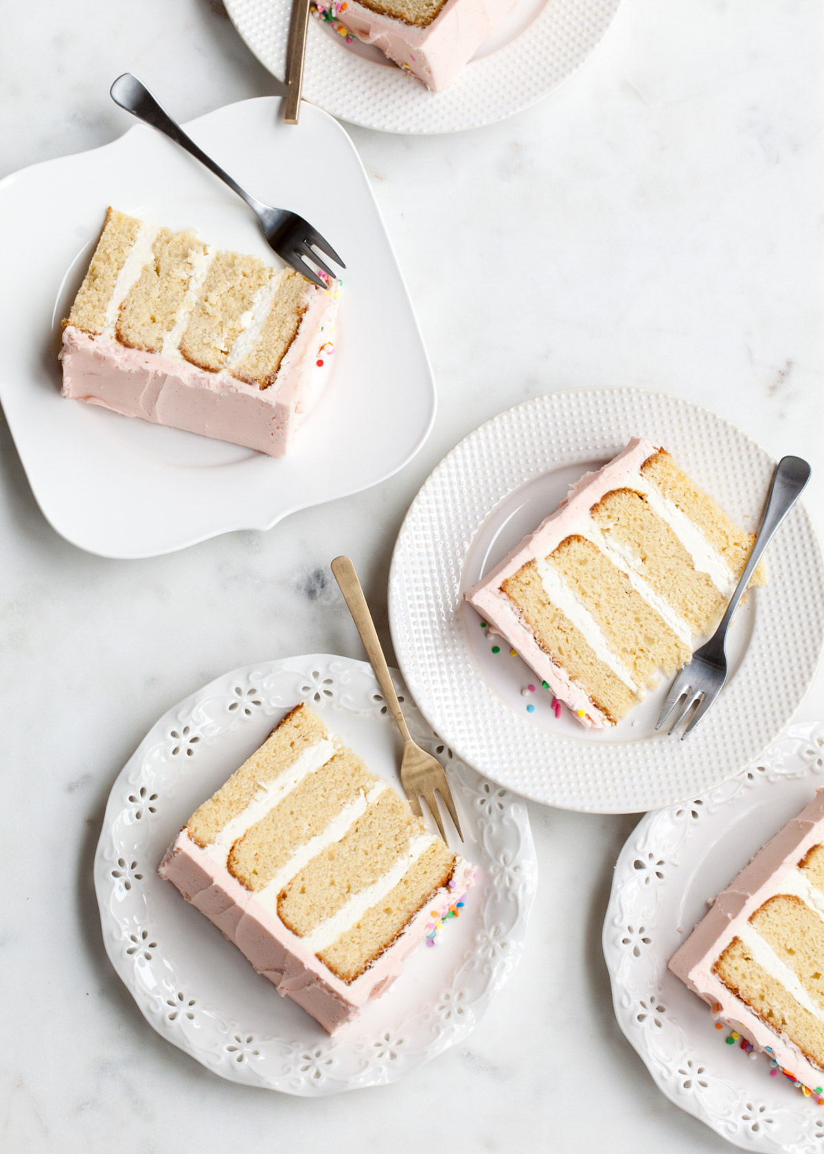 Slices of vanilla bean layer cake with pink buttercream