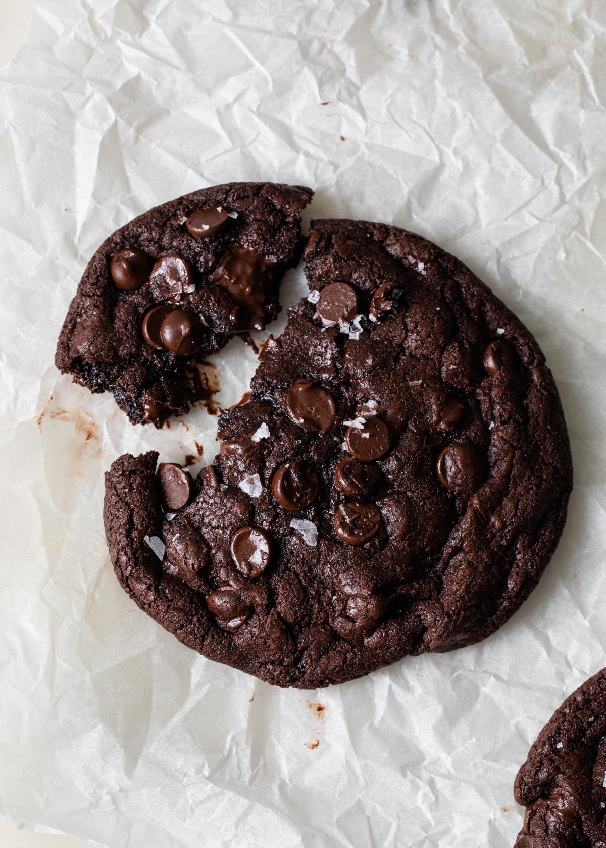 A giant double chocolate chip cookies with melted chocolate chips and flaky sea salt