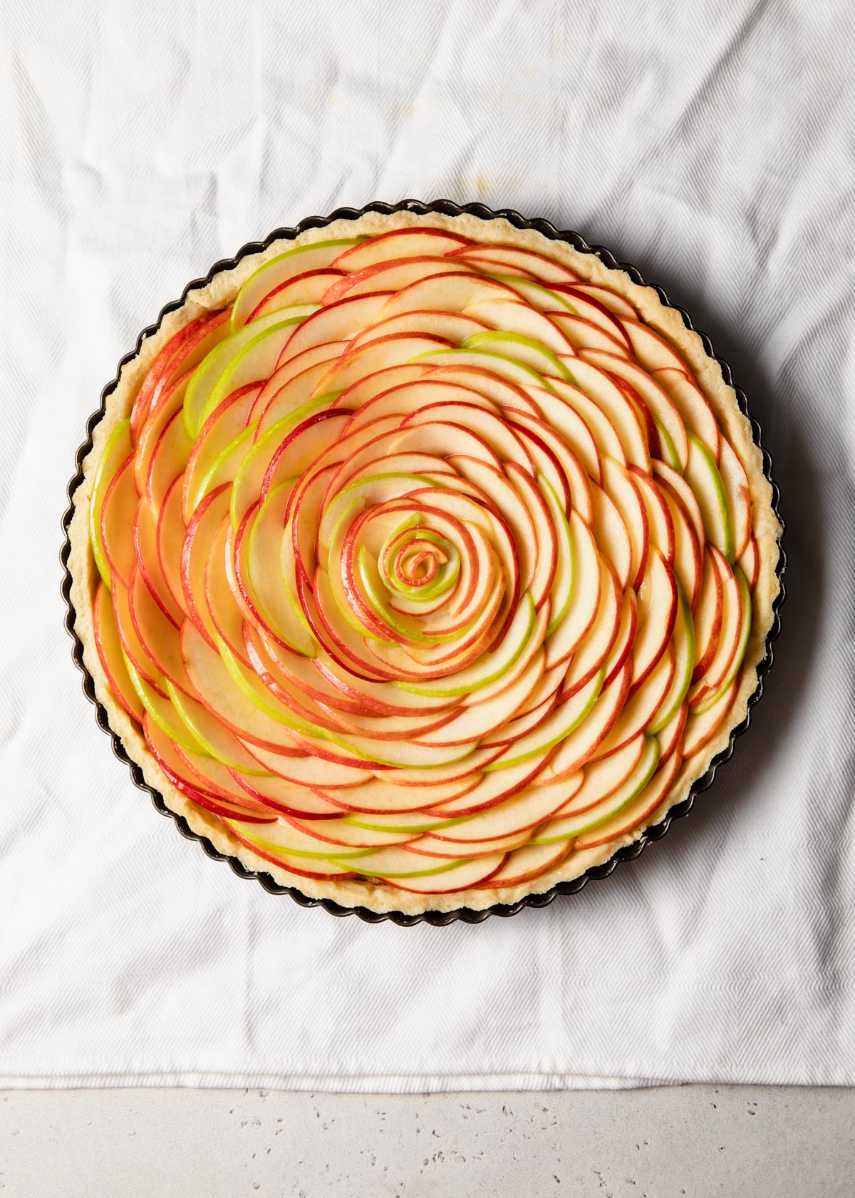 An apple rose tart in a pan ready to be baked