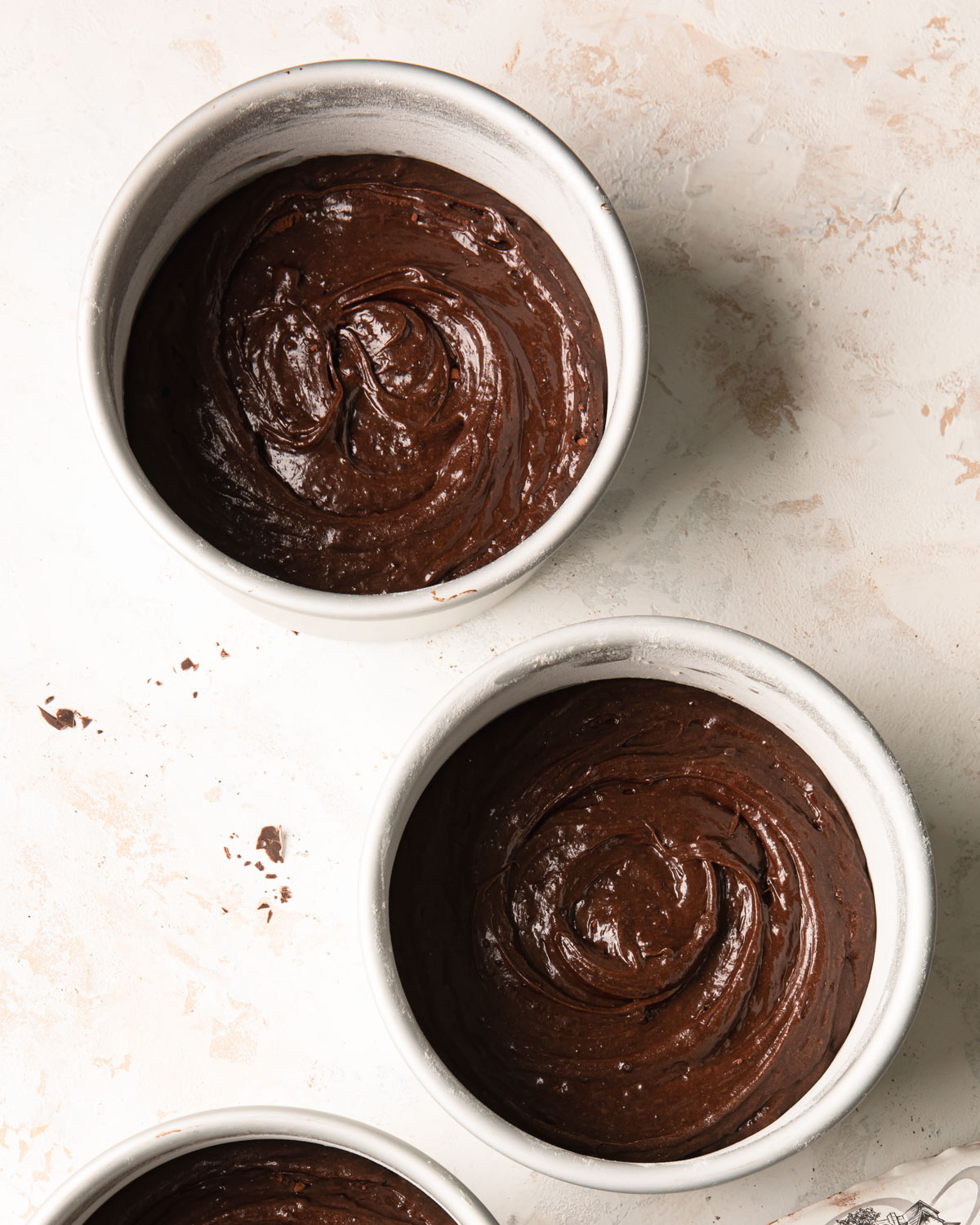 Chocolate brownie cake batter in the pans