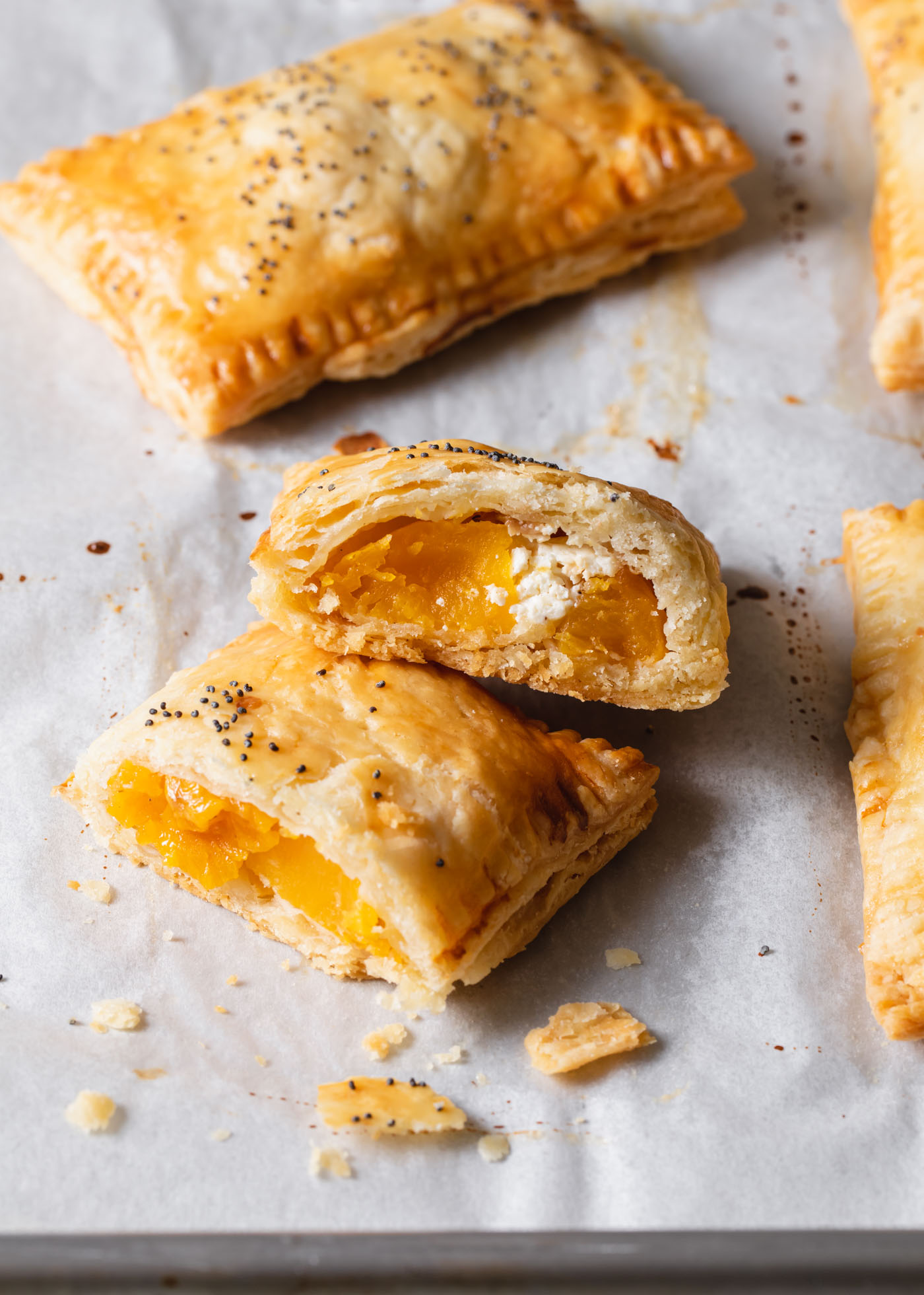 A cross-section of baked butternut squash hand pies on a baking sheet