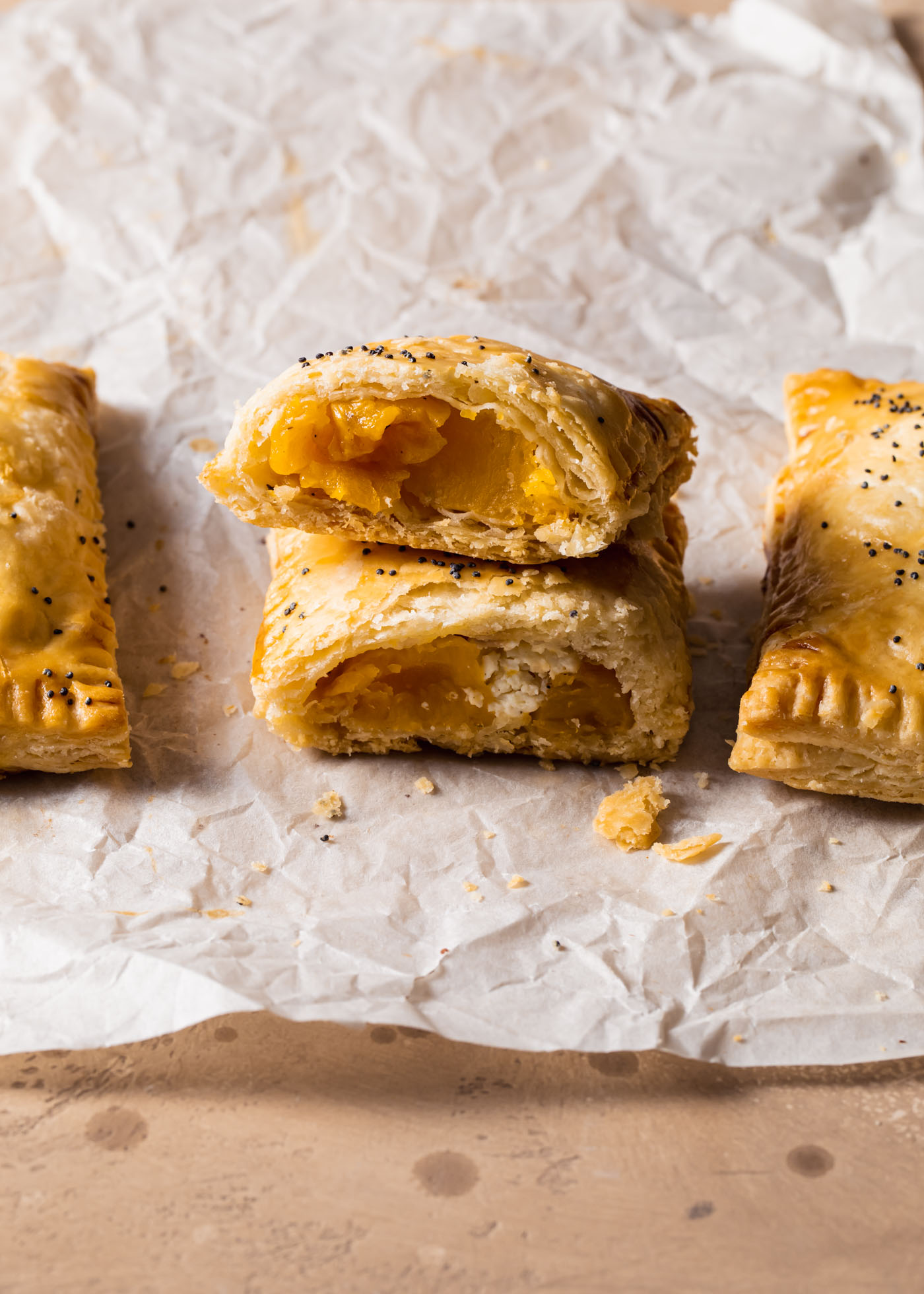 A cross-section of butternut squash hand pies with goat cheese inside and a flaky crust.