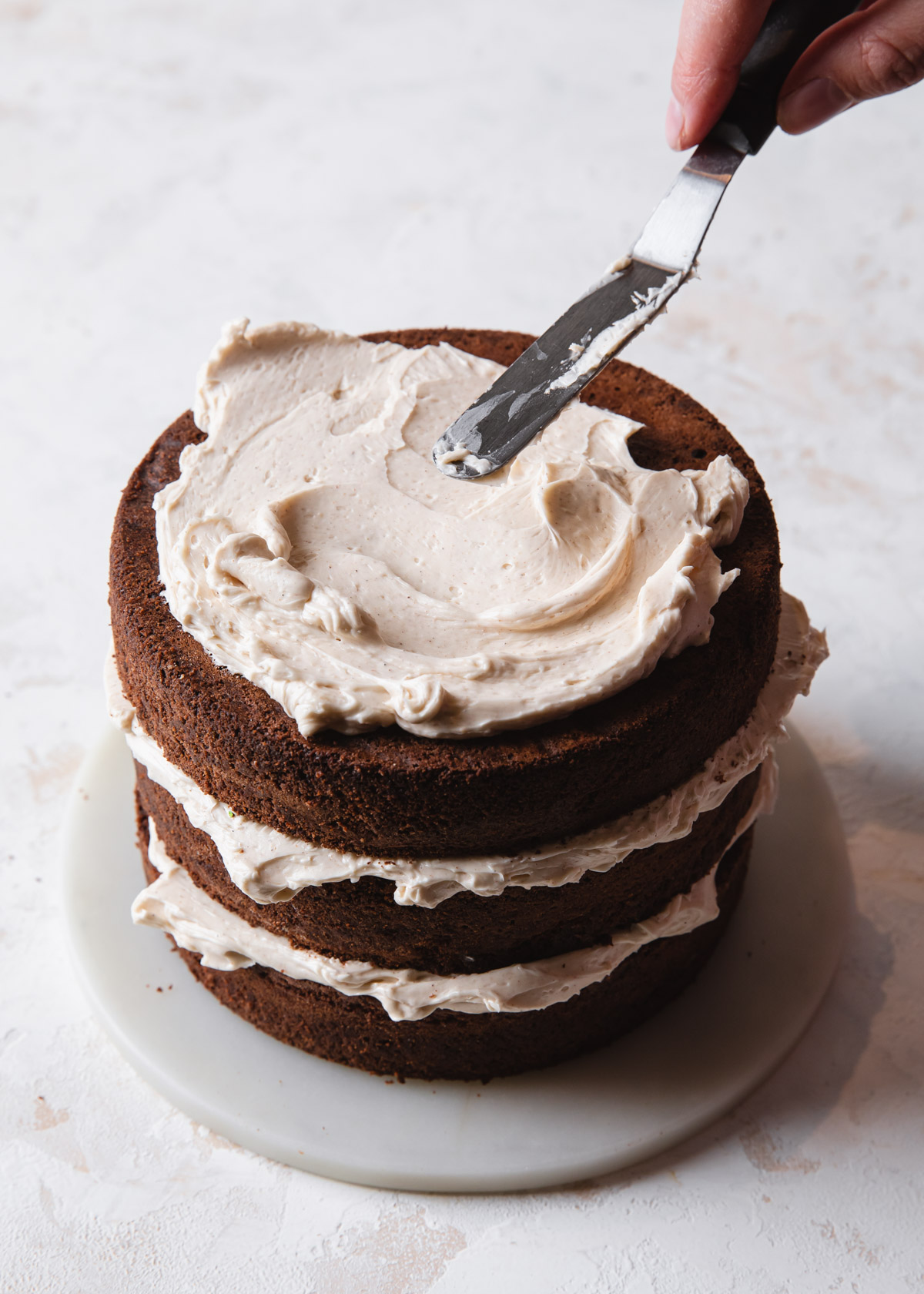 Frosting a chocolate brownie cake