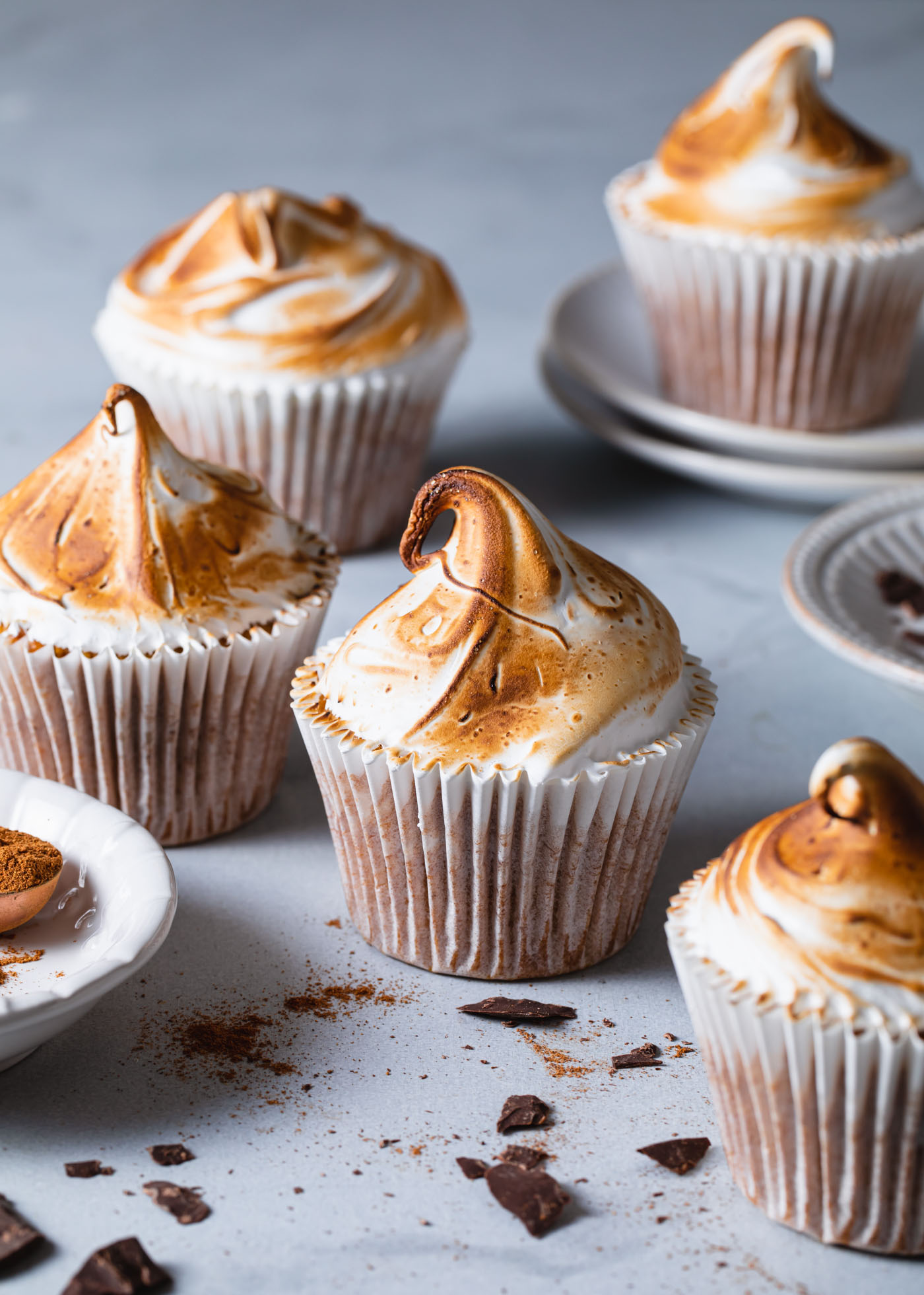 Pumpkin S'mores Cupcakes with meringue topping that has been toasted and scatters of chocolate and pumpkin pie spice