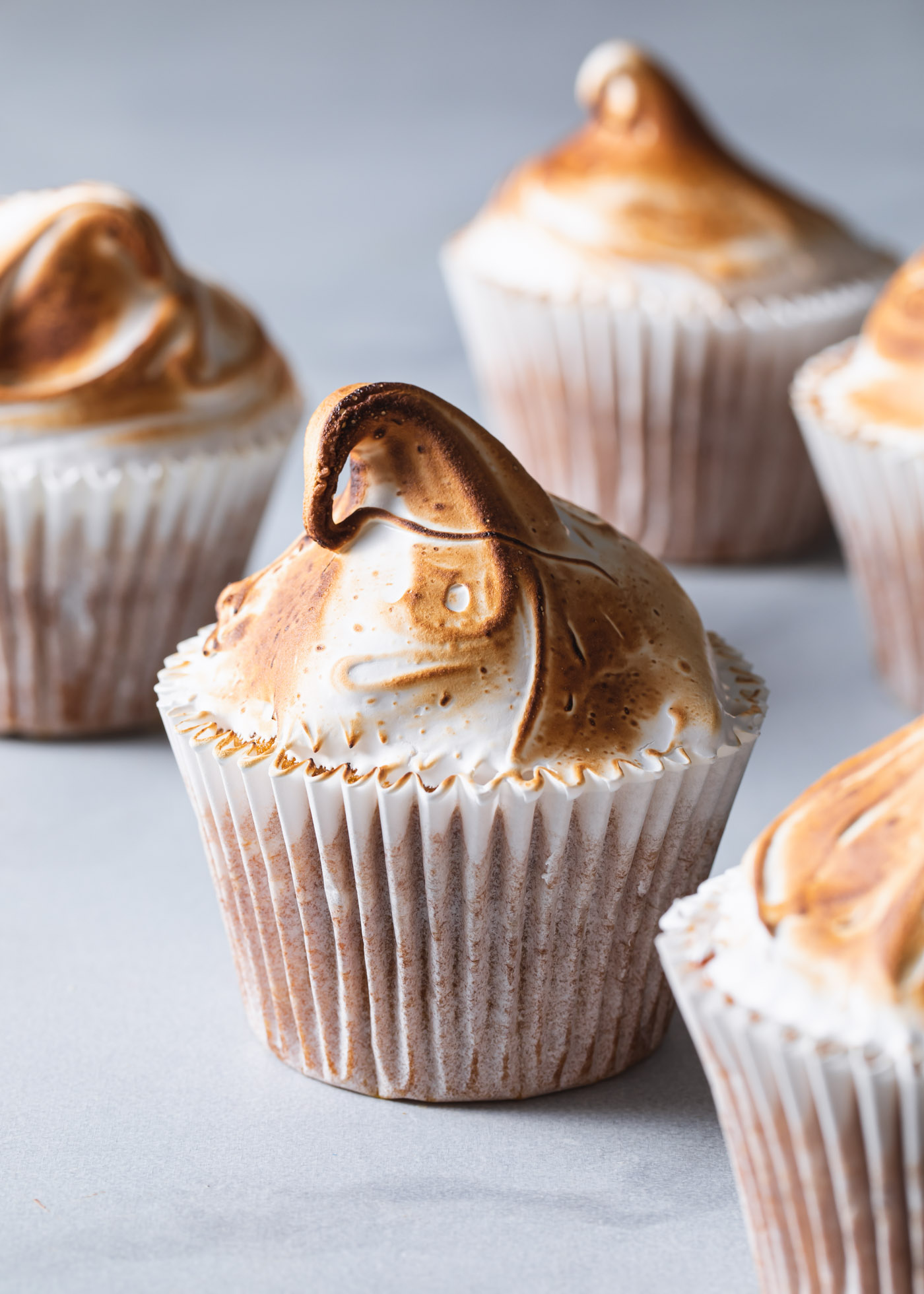 Pumpkin cupcakes with meringue frosting that has been toasted with a kitchen torch