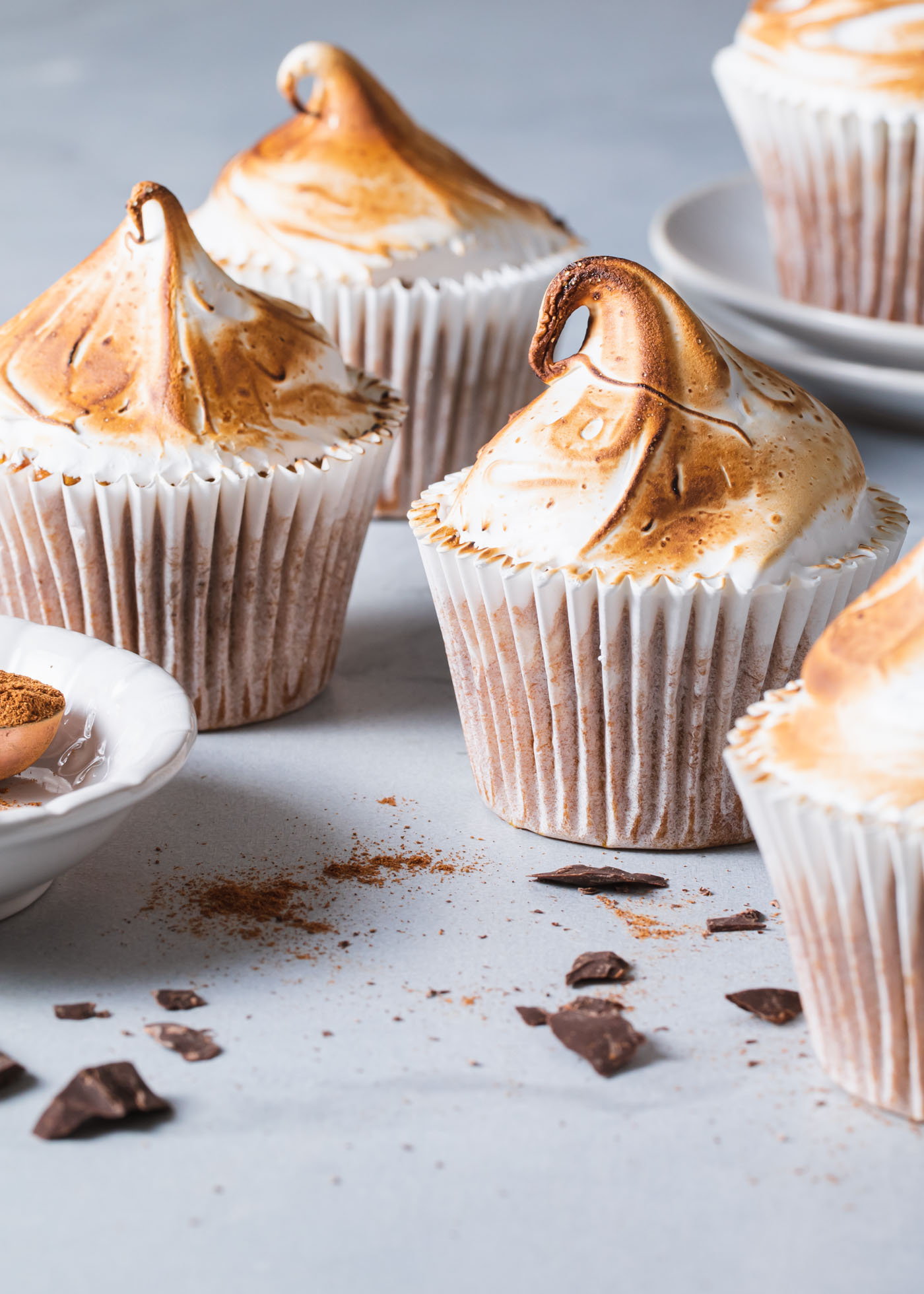 A close-up of pumpkin s'mores cupcakes with toasted meringue swirls on top