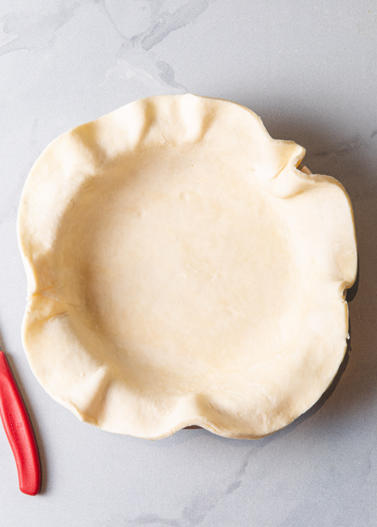 Pie dough in a pie pan before baking